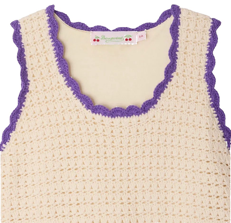 The Bonpoint Girls' Lali Hand-Crocheted Dress is a sleeveless cream dress with purple scalloped trim along the neckline and armholes—a charming handmade piece for any occasion.