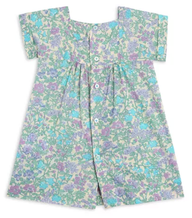 The Bonpoint Girls' Pais Smocked Dress features short sleeves, a button front, and a smocked neckline with a green, purple, and blue liberty floral print, shown laid flat on a white background.