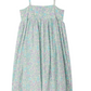 The Girls' Passion Dress by Bonpoint is a sleeveless sundress made from organic cotton, featuring thin straps, a gathered skirt, and a floral print in light blue, purple, and green tones.