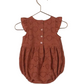 The Noralee Baby Girls' Betsy Romper in rust features a heart eyelet design, bubble shape, ruffle cap sleeves, and three back buttons, shown here displayed on a hanger.