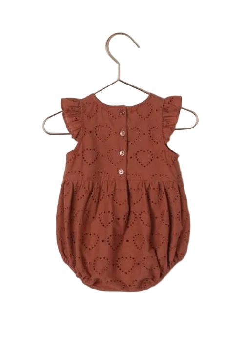 The Noralee Baby Girls' Betsy Romper in rust features a heart eyelet design, bubble shape, ruffle cap sleeves, and three back buttons, shown here displayed on a hanger.