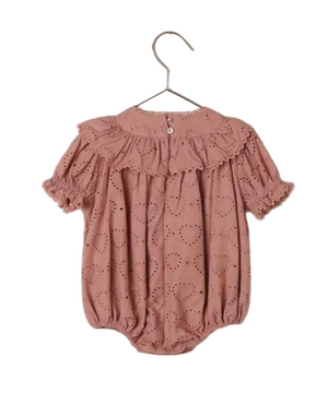 The Noralee Baby Girls' Eva Romper, in pink with heart eyelet fabric, lace trim, frill collar, and short sleeves, features button closure and is shown on a hanger against a white background.