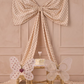 The Noralee Girls' Fairy Set features two butterfly-wing kids’ chairs, a cake-topped round table, and a large polka-dot bow backdrop, creating the perfect dress-up party scene against a light pink wall.