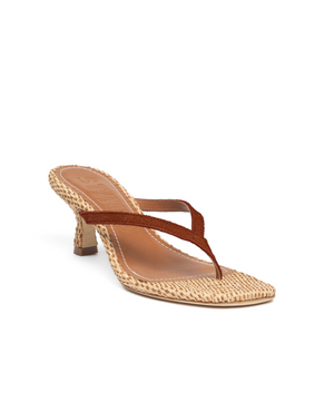 The Staud Freja Thong Suede Kitten Heel showcases a brown suede thong strap and a woven beige sole with a subtle kitten heel, set against a white background.