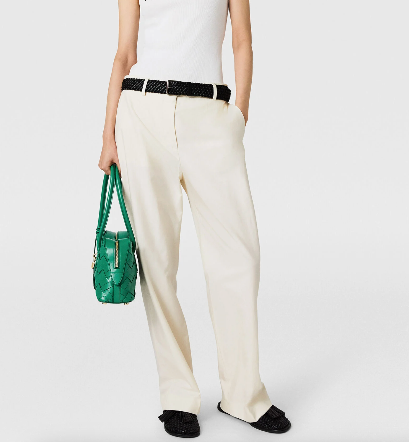 A person in a white sleeveless top, black sandals, holding a green woven handbag and wearing Stella McCartney Washed Cotton Straight Trousers—an effortlessly polished look with versatile tailoring.