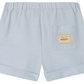 Bonpoint Baby Boys' and Boys' Ecady Shorts in light blue chambray feature rolled cuffs, a comfy elastic waistband, and a back patch pocket with a beige Bonpoint label.