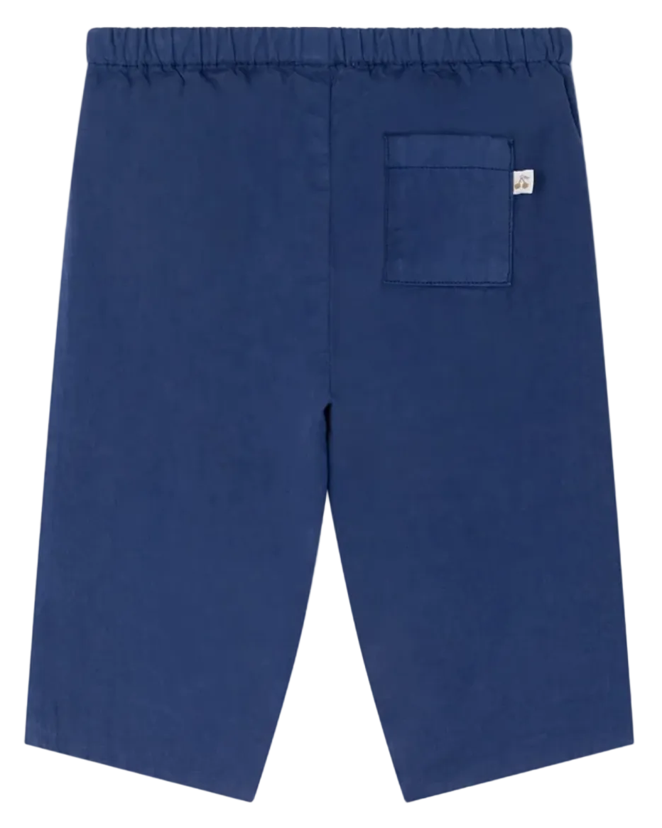 Bonpoint's Baby Boys' and Boys' Dandy Indigo Trousers feature soft organic cotton, an elastic waistband, and a back pocket with a white tag—ideal for babies.