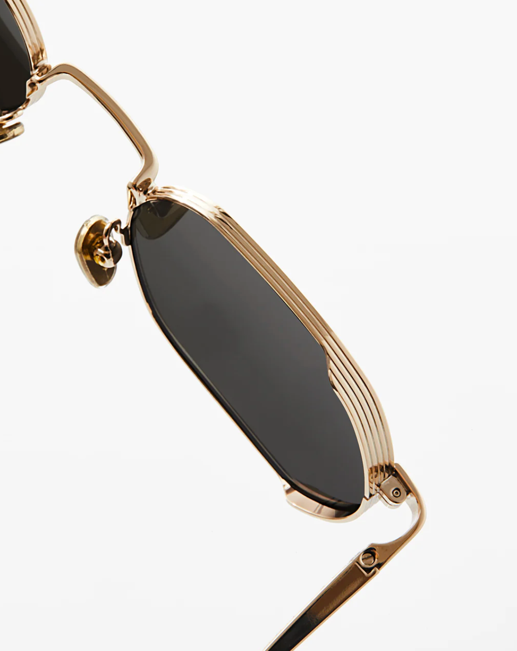 Close-up of Jimmy Fairly's Ben sunglasses, featuring gold stainless steel round frames with black lenses, detailed nose pads, and acetate sleeves, set against a plain white background.