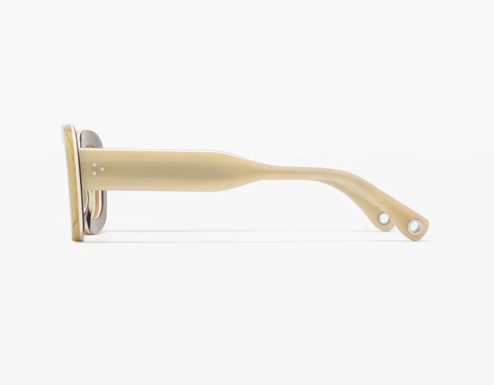 Side view of the Ily Sunglasses by Jimmy Fairly, featuring a beige rectangular silhouette crafted from translucent cellulose acetate with two small holes near the end of the temple arm, set against a white background—a refined example of German eyewear craftsmanship.
