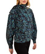 A person wearing the Ulla Johnson Pastel Long Sleeve Cotton Blouse, which features a structured silhouette with long sleeves and a high neck, paired with black pants and facing slightly to the side.