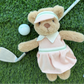 Dressed in a charming pink golf outfit, the Mon Ami Birdie Golf Bear relaxes on the grass beside a golf ball and an iron club, making this adorable golfer teddy bear the ultimate companion for any golf enthusiast.