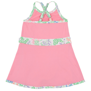Girls’ Prepletic™ Teggy Tennis Dress by The Beaufort Bonnet Company in pink, featuring floral trim, crisscross back straps, and an A-line silhouette—an ideal choice for girls’ activewear—shown against a plain white background.
