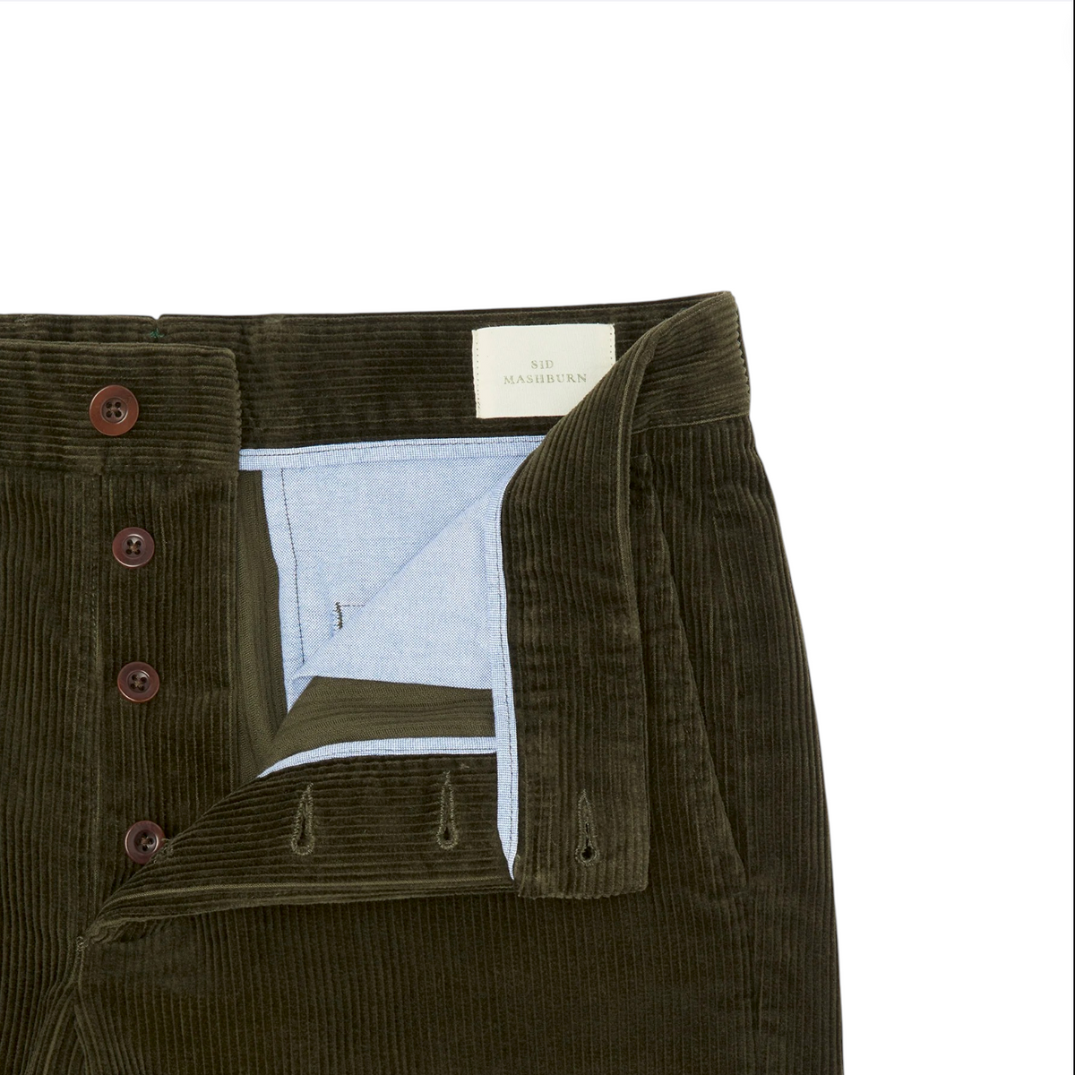 A close-up of the Sid Mashburn Field Pant in green wide-wale corduroy, featuring an open button fly with brown buttons and a light blue inner lining.