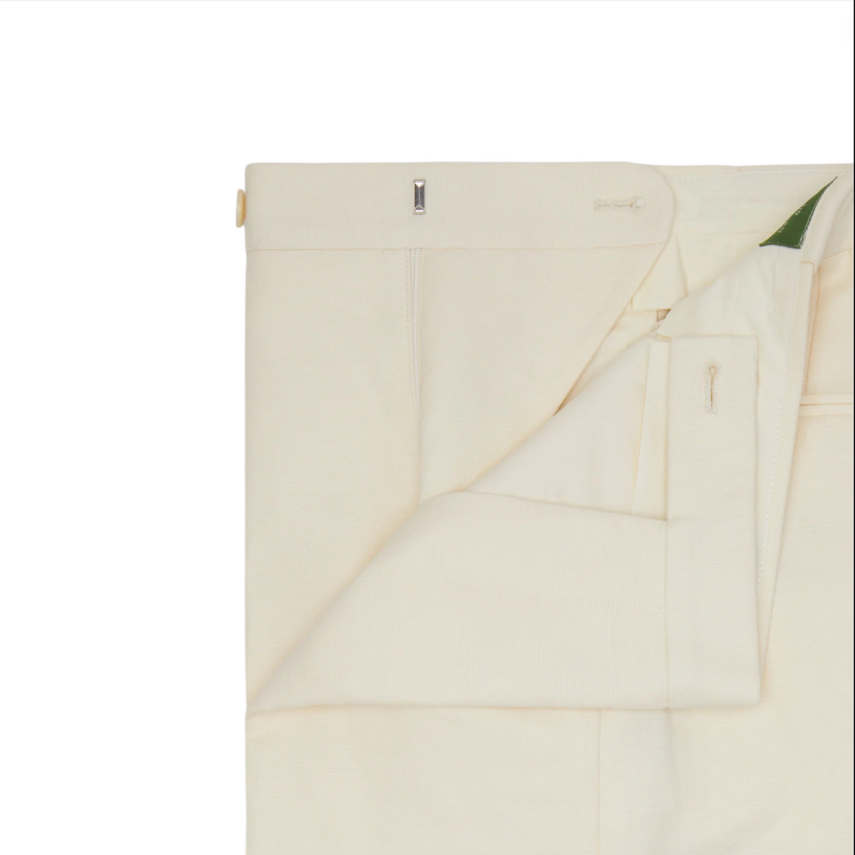 Close-up of Sid Mashburn’s Side-Tab Dress Trouser in ivory canvas, neatly folded to display the partially opened waistband and front closure with button and hook fastening. These expertly crafted flat-front trousers are made in Portugal.