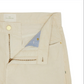 Close-up of the Slim Straight 5-Pocket Pant in cream-colored corduroy by Sid Mashburn, shown with the fly unzipped to reveal the interior button and part of the waistband label. These men’s casual pants are designed with a slim straight silhouette for a modern yet timeless appeal.