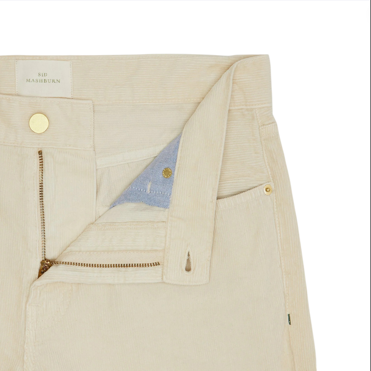Close-up of the Slim Straight 5-Pocket Pant in cream-colored corduroy by Sid Mashburn, shown with the fly unzipped to reveal the interior button and part of the waistband label. These men’s casual pants are designed with a slim straight silhouette for a modern yet timeless appeal.
