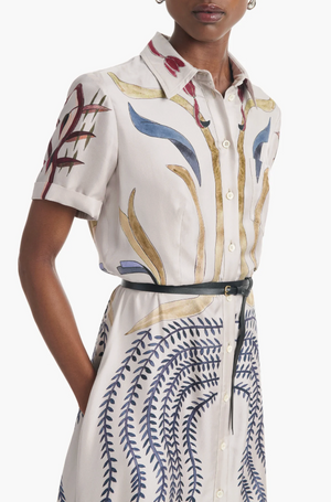 Woman wearing the Altuzarra Kiera Dress, a pure silk A-line with colorful abstract botanical print and slim leather waist belt, shown from shoulders to mid-thigh.