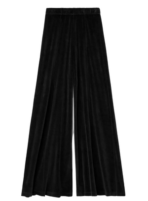 Black, full-flared Megalo Velour Pants with an elasticized waistband and front seam detail.
