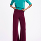 A person wearing a teal short-sleeved top and dark red wide-leg Suzie Kondi Zephyra Velour Pants.