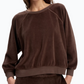 A person wearing a relaxed fit, dark brown Suzie Kondi Samos Velour Sweatshirt with a crew neckline and comfy sleeves.