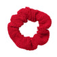 The Hunza G Scrunchie in red textured fabric is displayed on a white background—an ideal way to add vibrant color to your hair accessories collection.
