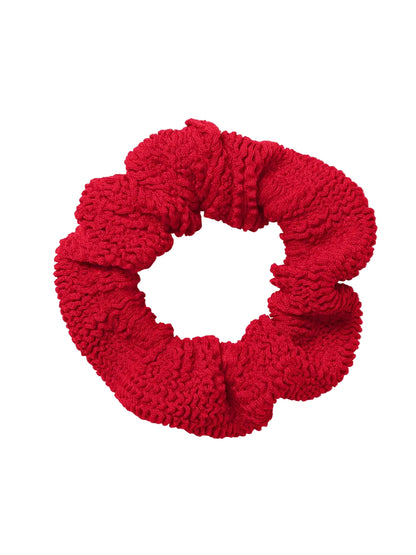The Hunza G Scrunchie in red textured fabric is displayed on a white background—an ideal way to add vibrant color to your hair accessories collection.