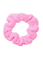 The Hunza G Scrunchie features a textured pink crinkle fabric with a ruffled design, adding charm and flair to your hair accessories collection. Shown on a white background.