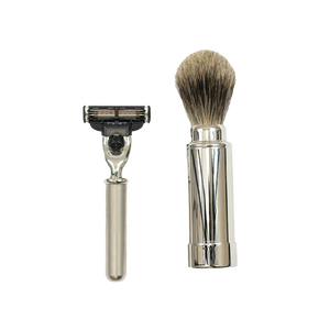 The Barberino's Travel Set, featuring a silver-handled razor and a luxury badger hair shaving brush, is displayed side by side on a white background.