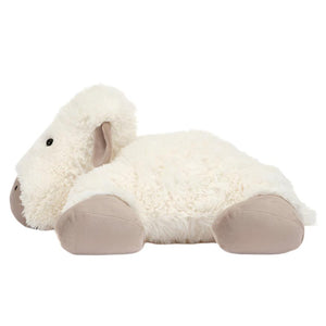 The Jellycat Truffles Sheep by Jellycat is a plush toy shaped like a sheep, lying flat on its stomach. It features white, fluffy fur and beige feet and face, making it the perfect naptime companion.