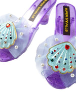 The Mermaid Dreams Play Shoes by Super Smalls are purple heeled children's sandals with tulle, faux pearls, and gem seashell heels—perfect for kids who love magical mermaid dress up.