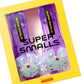 A pair of purple Super Smalls Mermaid Dreams Play Shoes for kids, featuring shell and heart designs, packaged in a yellow box.