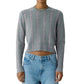 Grey shrunken cashmere Shrunken Checker Crew sweater with vertical pink pinstripes worn with light-wash blue jeans.