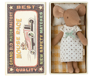 A Maileg Big Sister Mouse in a nightgown is placed inside an open matchbox bed labeled “Mouse Race - Best Quality.” The matchbox, which serves as a cozy toy for kids, features an illustration of a car.