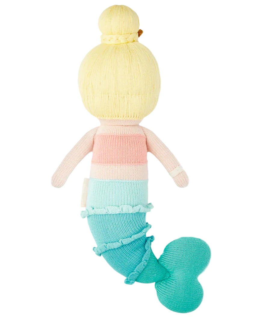 Skye the Mermaid - Regular 20" by Cuddle + Kind is a knit plush doll with blonde hair in a bun, a pastel pink and blue top, and a blue-turquoise tail—perfect for imaginative ocean-themed play.