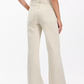 A person stands facing away, wearing Rag & Bone's Skylar High Rise Trouser Jean in vintage stretch denim with a sleeveless striped top, showcasing the back view of the outfit.
