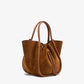 The Small Ruched Soft Suede Tote by Proenza Schouler, crafted in brown suede with leather handles and a drawstring detail, features a sculptural silhouette and is displayed on a plain white background.