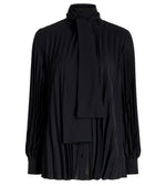 The Proenza Schouler Soomin Technical Crepe Top is a black, long-sleeve blouse with accordion pleats and a high neck with an attached tie detail at the collar.