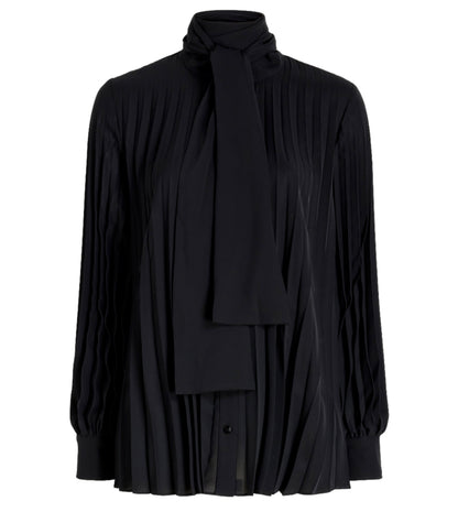 The Proenza Schouler Soomin Technical Crepe Top is a black, long-sleeve blouse with accordion pleats and a high neck with an attached tie detail at the collar.