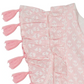 Close-up of the Mer Girls' Sophie Tassel Dress fabric, showcasing pink and white stripes, ruffles, white anchor motifs, and pink tassels along the edge.