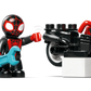 A LEGO® DUPLO® figure in a black and red suit with a blue wrench stands beside a matching motorcycle, inspired by LEGO® DUPLO® Spin's Motorcycle Adventure—an exciting preschool learning toy for imaginative play.
