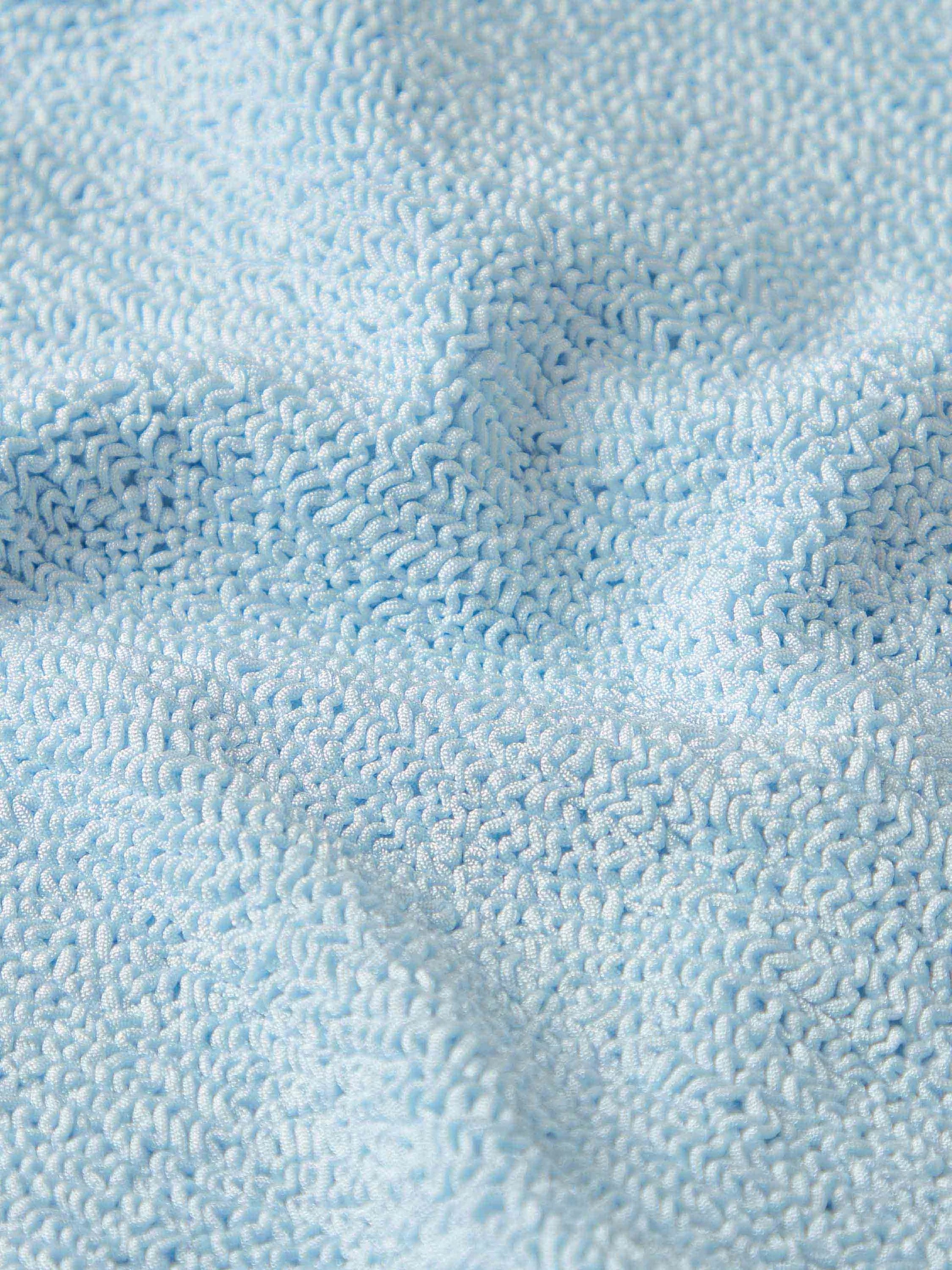 Close-up of the light blue Square Neck Swim by Hunza G, featuring crinkle fabric with small loops and subtle surface wrinkles.
