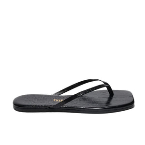 The Tkees Lily Square Toe Croc Sandal is a black flip-flop with thin straps, a textured sole, and a flat square toe—ideal for those seeking elegant footwear with modern style.