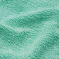 Close-up of the Pamela Swim by Hunza G, showcasing its textured, light green Original Crinkle™ fabrication with visible fibers and subtle wrinkles.