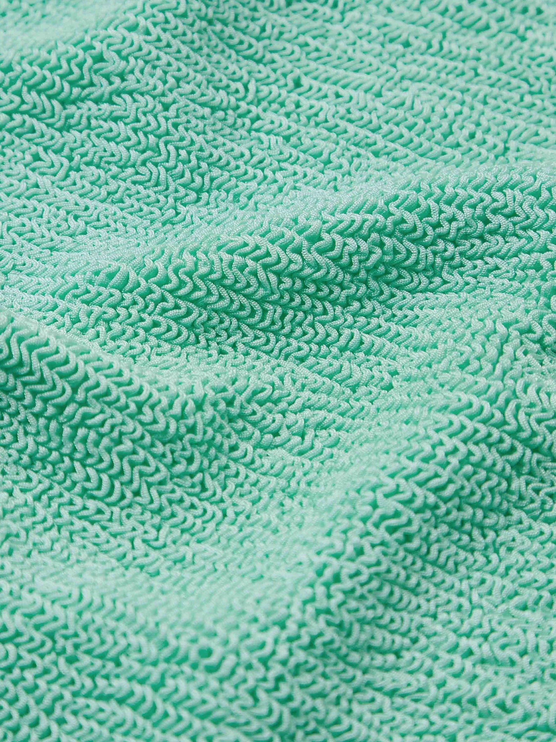 Close-up of the Pamela Swim by Hunza G, showcasing its textured, light green Original Crinkle™ fabrication with visible fibers and subtle wrinkles.