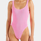 A woman wearing the Square Neck Swim by Hunza G, a textured light pink one-piece crafted from the brand’s signature Original Crinkle™ fabric and featuring a square neckline and high-cut legs, stands against a plain background.