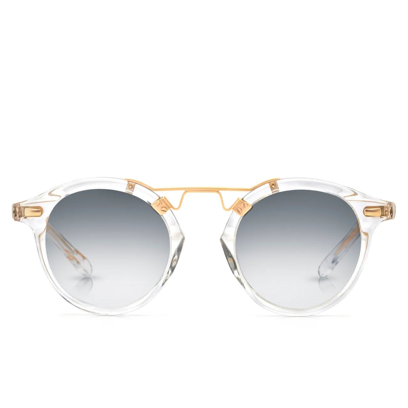 Krewe St. Louis Mirrored Sunglasses feature clear acetate round frames, a gold metal bridge, and a classic silhouette with grey gradient lenses, all displayed against a white background.