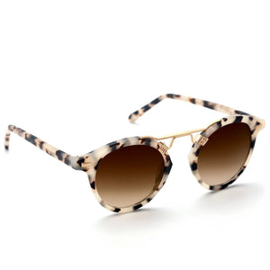 The Krewe St. Louis Sunglasses feature a round tortoiseshell frame with a beige and black pattern, gold bridge, and brown gradient lenses for classic style, shown on a white background.