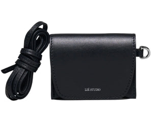 The Lie Studio Stella Wallet is a compact black crossbody bag made from Italian cow leather with a flap closure, detachable strap, and "LIÉ STUDIO" logo embossed on the front—a sophisticated and versatile accessory.