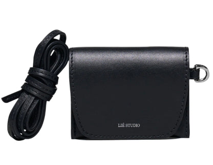 The Lie Studio Stella Wallet is a compact black crossbody bag made from Italian cow leather with a flap closure, detachable strap, and "LIÉ STUDIO" logo embossed on the front—a sophisticated and versatile accessory.