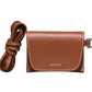 A compact brown Italian cow leather Stella Wallet by Lie Studio, with white stitching, a flap closure, and a detachable strap beside it. "LIE STUDIO" is printed on the front, giving it a stylish and versatile look.